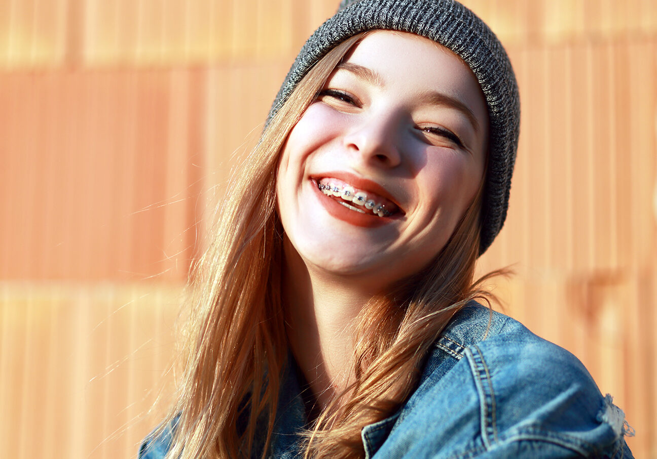 beautiful blond teen girl with braces on her teeth smiling